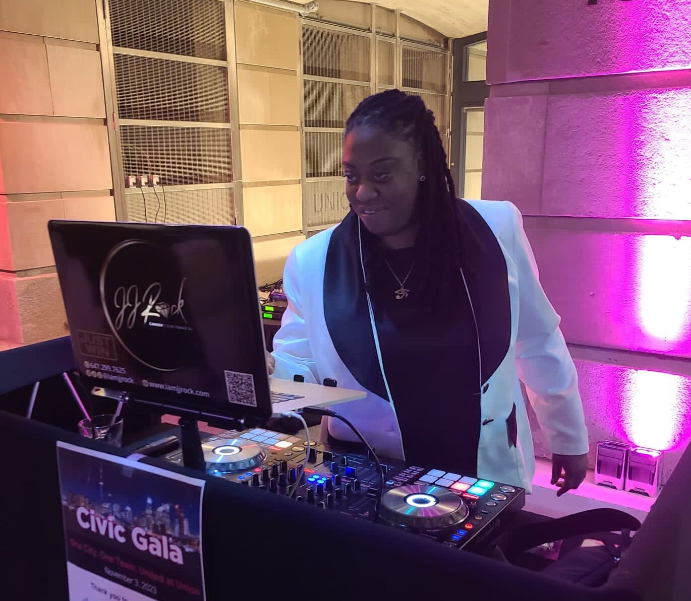 DJ JJ Rock performing in a black-and-white blazer at a civic gala