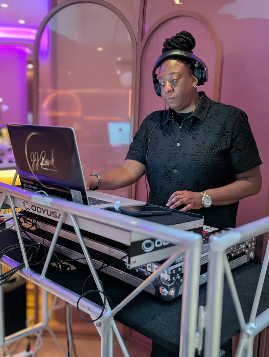 DJ JJ Rock wearing headphones while working at her laptop and DJ controller