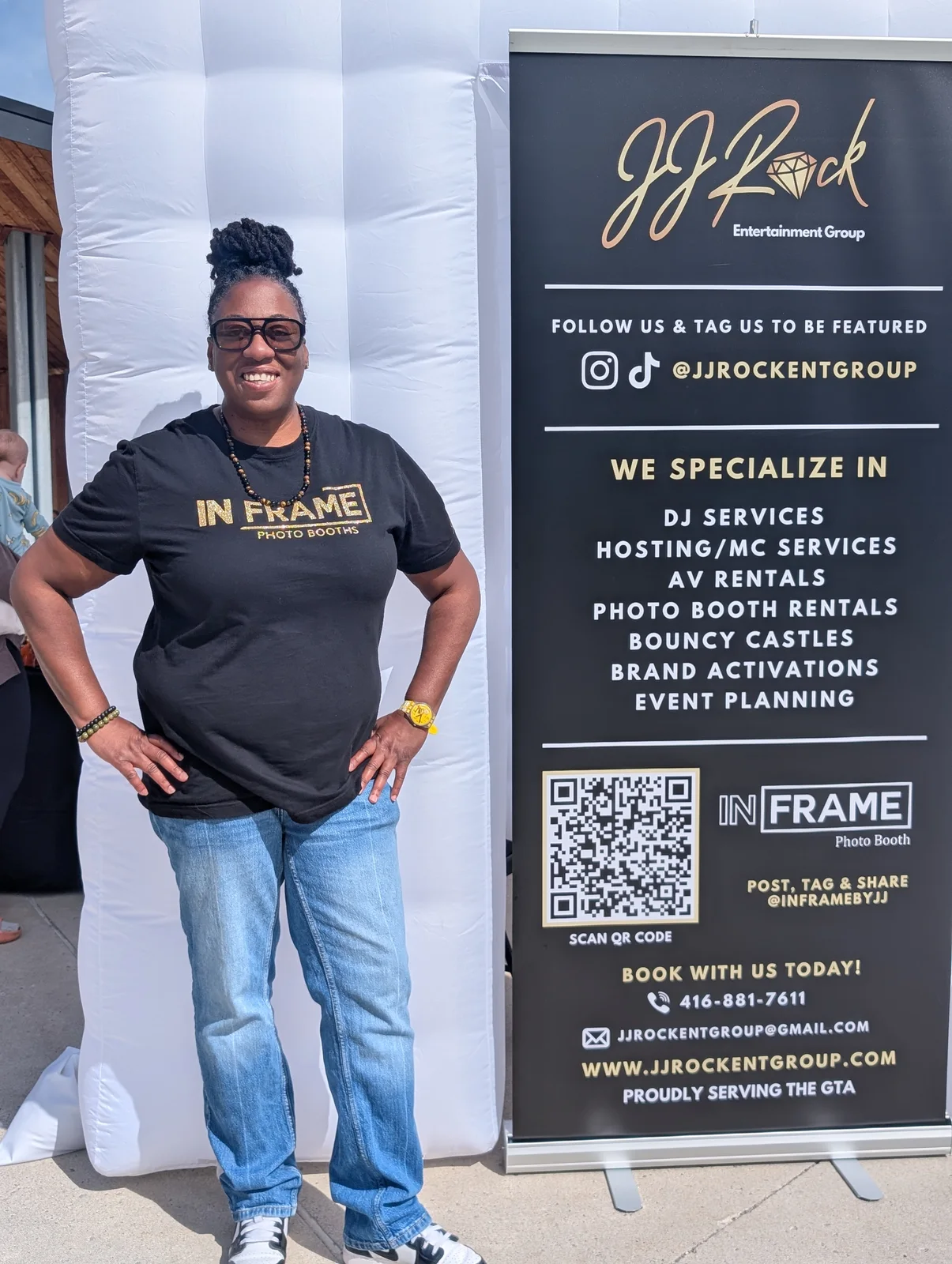 Jeannine wearing an In Frame Photo Booths shirt beside the JJ Rock Entertainment Group banner
