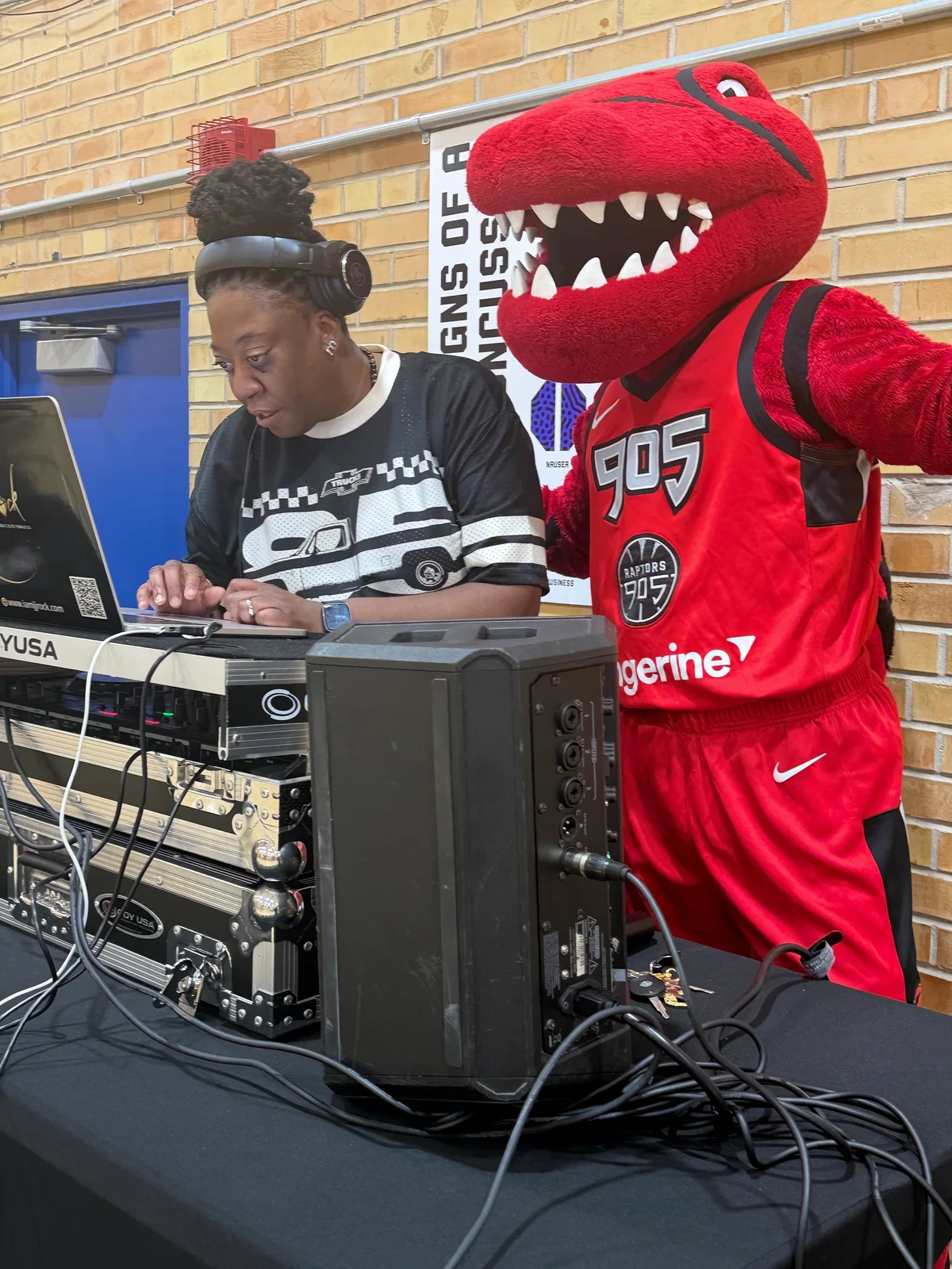 JJ Rock operating her DJ equipment beside the Raptors 905 mascot