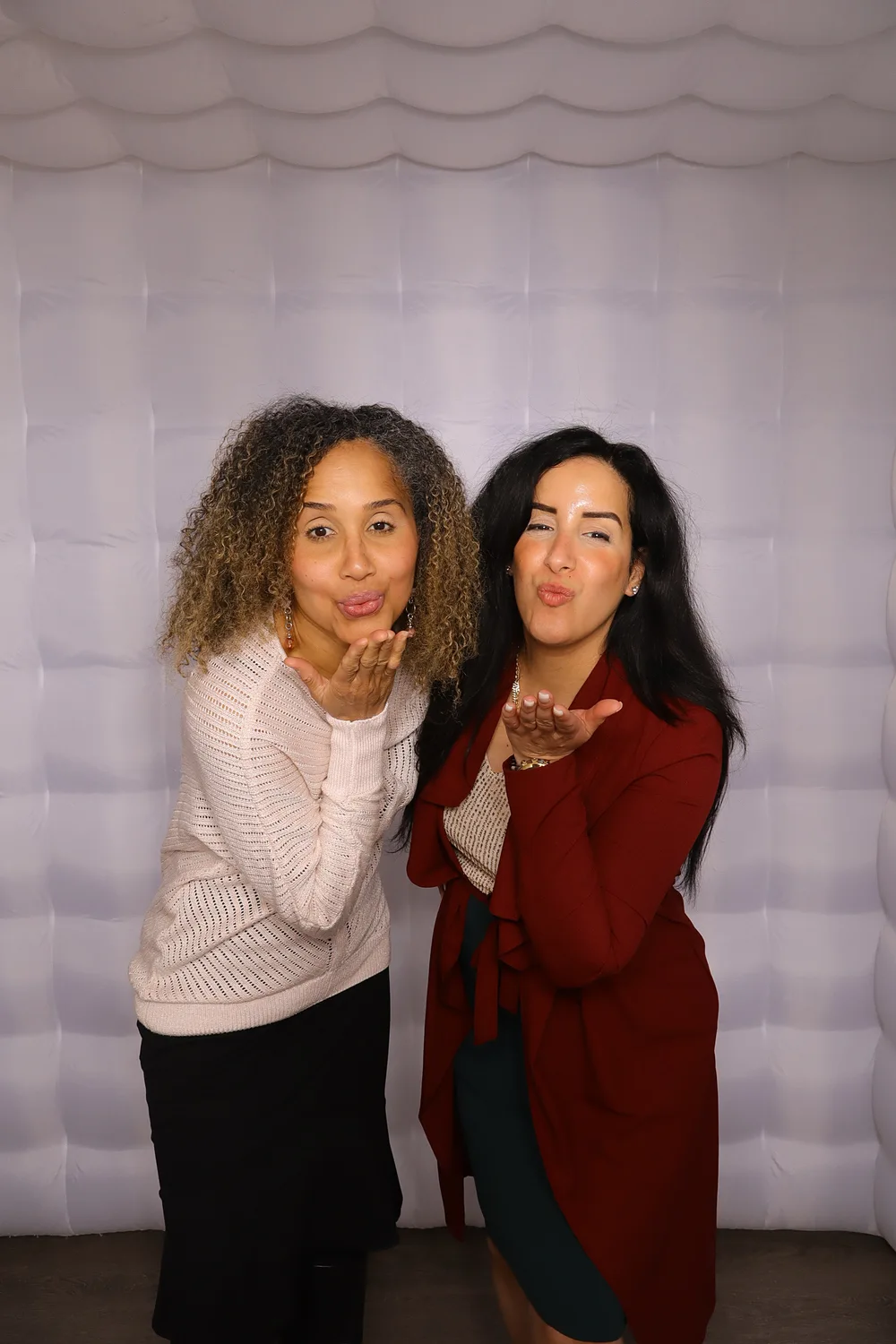 Two guests posing inside the inflatable photo booth enclosure