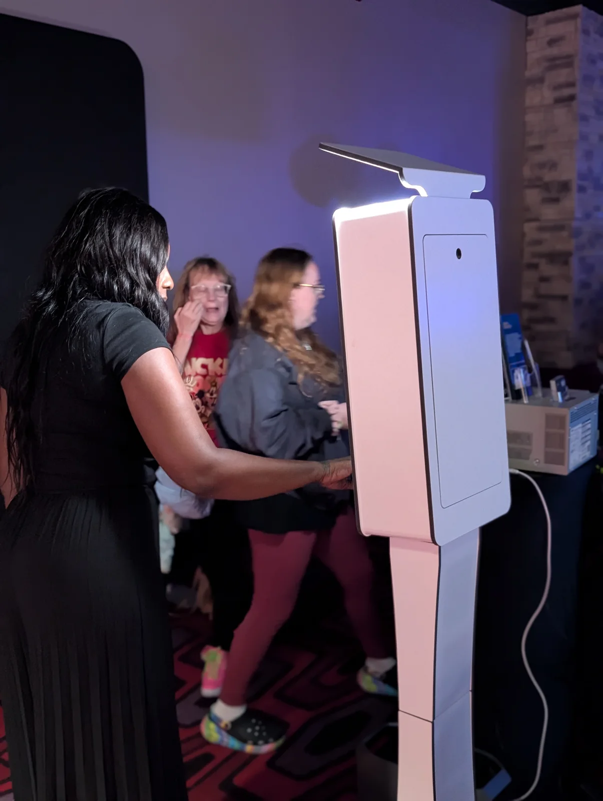 JJREG photo booth partner operating a white digital booth with guests nearby